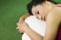 Women sleep on the green grass, a beautiful and dreamy Thai woman laying down on green grass, relaxing Royalty Free Stock Photo