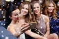 Women with smartphone taking selfie at night club