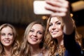 Women with smartphone taking selfie at night club Royalty Free Stock Photo