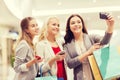 Women with smartphones shopping and taking selfie