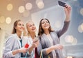 Women with smartphones shopping and taking selfie