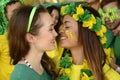 Women soccer fans almost kissing each other.