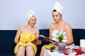 Women at spa in waiting room read magazines Royalty Free Stock Photo