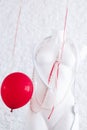 Women special days. Red ballon floating near white female mannequin for clothes in necklaces on brick wall background