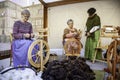 Women spinning thread with a wooden spinning wheel Royalty Free Stock Photo