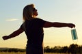 The women spread their arms out on the meadow at sunset and held the protective medical mask in their hands. Royalty Free Stock Photo