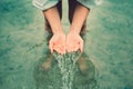 A women stand in the water and hands fetch water and have water splash