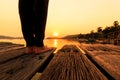 A Women stand on wooden floor near the sea with sunset Royalty Free Stock Photo