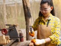 Women standing builder wearing checked shirt worker of construction site hammering nail in the wooden Royalty Free Stock Photo