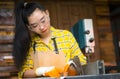 Women standing is craft working cut wood at a work bench with circular saws power tools at carpenter machine Royalty Free Stock Photo