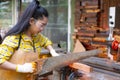 Women standing is craft working cut wood at a work bench with circular saws power tools at carpenter machine Royalty Free Stock Photo