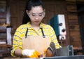 Women standing is craft working cut wood at a work bench with circular saws power tools at carpenter machine Royalty Free Stock Photo