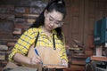 Women standing is craft working cut wood at a work bench with circular saws power tools at carpenter machine Royalty Free Stock Photo