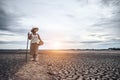 Women standing on dry soil and fishing gear, global warming and water crisis Royalty Free Stock Photo