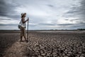 Women standing on dry soil and fishing gear, global warming and water crisis Royalty Free Stock Photo