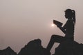 Women standing holding holy bible for worshipping God at sunset background, Pray to the god, christian silhouette concept