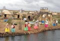 Women standing by the lake shore at Uros floating islands in Lake Titicaca in Peru