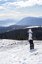 Women standing in a snowy winter landscape and is ponting the finger on the beautiful view from the top of a mountain Royalty Free Stock Photo