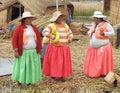 Women standing by straw houses at Uros floating islands in Lake Titicaca in Peru