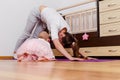 A woman stands in a dog pose muzzle down. Yoga at home. mother and child. Quarantine