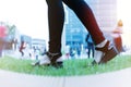 Women step forward to success, young women is stepping forward on green grass near business building Royalty Free Stock Photo