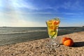 glass of lemon orange water on stone rock,blue t sea and sky nature landscape Royalty Free Stock Photo