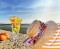 Women straw hat and glass of lemon orange water on stone rock,blue t sea and sky nature landscape Royalty Free Stock Photo