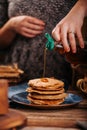 Women stream delicious mapple syrup for home made american pancakes