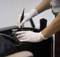 women stylist in gloves preparing color cream for dying hairin a container