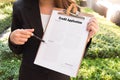 Women in suit showing approved credit application and pointing w