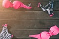 Women swimsuit lying on wooden background. Top and bottom part of swimwear. Colorful. Pink and black with white stripes.