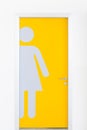 Women symbols on yellow public toilet entrance door.