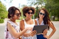 Women with tablet pc on street in summer