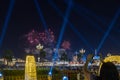 Women taking pictures of fireworks with here mobile phone in the evening with light beams shooting towards the sky Royalty Free Stock Photo