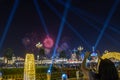 Women taking pictures of fireworks with here mobile phone in the evening with light beams shooting towards the sky Royalty Free Stock Photo