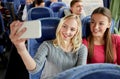 Women taking selfie by smartphone in travel bus Royalty Free Stock Photo