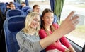 Women taking selfie by smartphone in travel bus Royalty Free Stock Photo