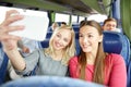 Women taking selfie by smartphone in travel bus Royalty Free Stock Photo