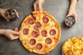 Women taking tasty pepperoni pizza at table, top view Royalty Free Stock Photo