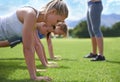 Women, teamwork and push ups on grass for fitness with exercise, training and coach on sports field. Athlete, people and