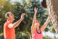 A woman throwing a medicine ball with the help of a sports instructor.