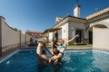 a woman about to fall into the water while playing wheelies with two couples more in a swimming pool Royalty Free Stock Photo