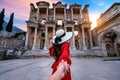 Women tourists holding man`s hand and leading him to Celsus Library at Ephesus ancient city in Izmir, Turkey.