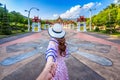 Women tourists holding man`s hand and leading him to Ho kham luang northern thai style in Royal Flora ratchaphruek in Chiang Mai,T