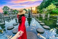 Women tourists holding man\'s hand and leading him to Tirta Gangga Water Palace in Bali, Indonesia Royalty Free Stock Photo