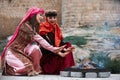 Women in traditional Azerbaijani dress warming hands above the bonfire