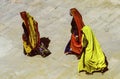 Women in traditional clothes walk barefoot in the temple area in