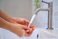Women turn on the water to wash their hands in the bathroom. Frequent hand washing to help clean, reduce the accumulation of