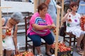 Women tying tomatoes together to form the hanging bunches during Tomato `Ramellet` Night Fair Royalty Free Stock Photo