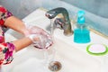 Women use liquid soap for rubbing and washing her hands under the water tap. Royalty Free Stock Photo